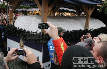 圣诞蛋糕 4.34 米长,1.77 米宽,0,47 米高,3.3 吨重。在3小时之内分给了60000位客人。每块以5欧元出售,部分善款将捐给Dresden德累斯顿麻雀少儿合唱团。(摄影:安迪/看中国) 圣诞蛋糕 4.34 米长,1.77 米宽,0,47 米高,3.3 吨重。在3小时之内分给了60000位客人。每块以5欧元出售,部分善款将捐给Dresden德累斯