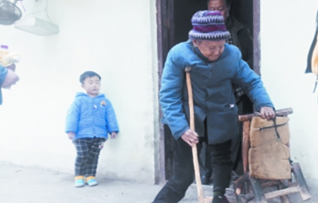 向从珍左手拿着小板凳，右手拄拐杖行走。（网络图片）