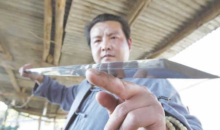 贾怀进凝视着自己所铸的汉剑。(网络图片) 贾怀进凝视着自己所铸的汉剑。(网络图片)