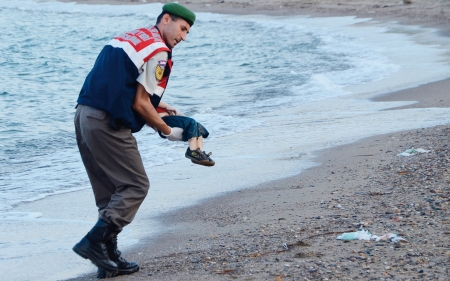 土耳其海岸警察在海滩上将遇难叙利亚幼童抱起。(AFP/Getty Images) 土耳其海岸警察在海滩上将遇难叙利亚幼童抱起。(AFP/Getty Images)