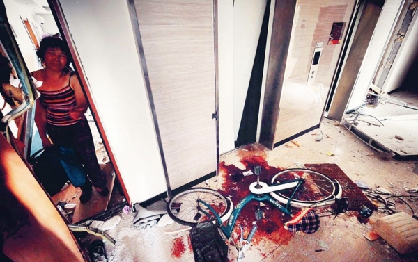 闯儿的母亲悲伤地看着儿子倒下的地方。（网络图片）