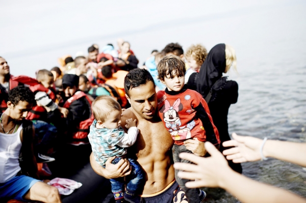 9月26日,一个男人抱着两个孩子和一批难民抵达希腊。(AFP/Getty Images) 9月26日,一个男人抱着两个孩子和一批难民抵达希腊。(AFP/Getty Images)
