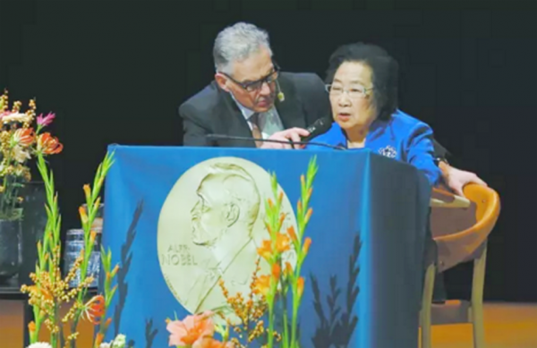 主持人安德森先生全程跪着,为屠呦呦拿着话筒。(网路图片) 主持人安德森先生全程跪着,为屠呦呦拿着话筒。(网路图片)