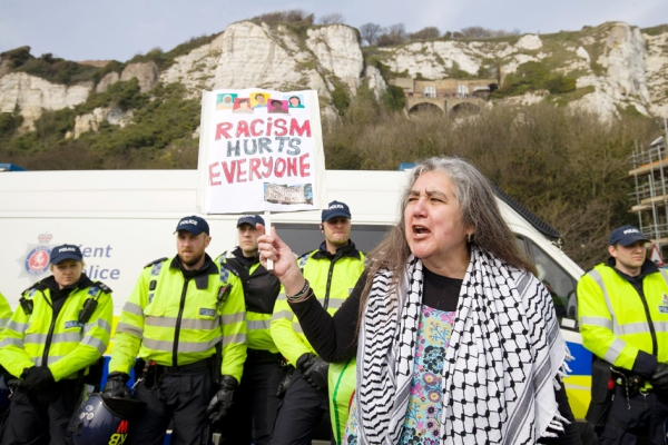 4月2日，一个极右团体的数十名抗议者在多佛地区游行，遭遇到来自反法西斯团体的反抗议。图为反种族主义示威者正举起标语。（AFP/Getty Images)