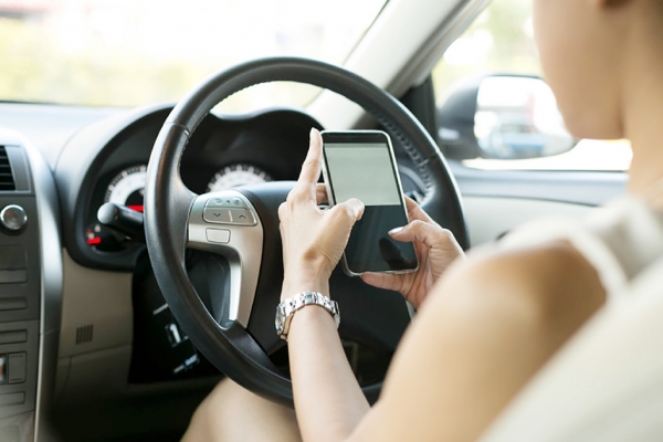 正在车上使用智能手机的司机（123RF）