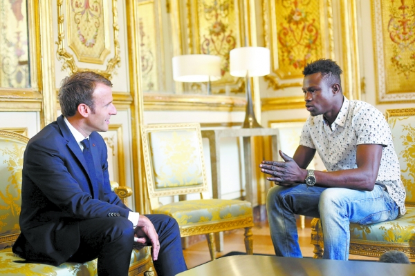 戛萨马(右)徒手攀登上了4层楼高的公寓,救下了一名悬在阳台外的男童。法国总统马克龙(左)5月28日在爱丽舍宫接见了戛萨马。(AFP/Getty Images) 戛萨马(右)徒手攀登上了4层楼高的公寓,救下了一名悬在阳台外的男童。法国总统马克龙(左)5月28日在爱丽舍宫接见了戛萨马。(AFP/Getty Images)