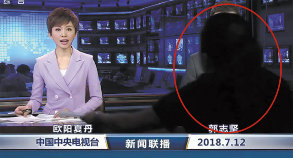 神秘黑衣人(红圈所示)遮挡住主播郭志坚。(视频截图) 神秘黑衣人(红圈所示)遮挡住主播郭志坚。(视频截图)