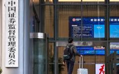 2025年11月12日，一名手提行李箱的男士走进位于北京的中国证券监督管理委员会（证监会）大楼。（图片来源：Cheng Xin/Getty Images）