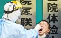 近日一名医务人员在武汉市抽取棉签样本。（Getty Images）