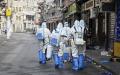 清零期间，上海防疫人员走街串巷强制消毒（STR/AFP via Getty Images）