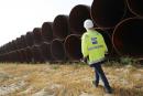 一名工人走在将铺设在“北溪二号”天然气运输管线的钢管前。(Getty Images)