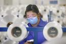 今年2月，一名带着口罩工作的江苏一纺织厂职工（AFP via Getty Images）
