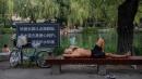 2022年7月7日北京高温天气，市民湖里游泳、湖边纳凉。（图片来源：Getty Images）