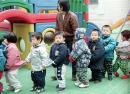 中国北京一所幼儿园的儿童在老师的带领下排队。（GOH CHAI HIN/AFP via Getty Images）