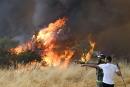 8月16日，在西班牙西北部，当地人和森林消防员正在努力扑灭一场野火。(MIGUEL RIOPA/AFP via Getty Images)
