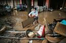 7月9日， 广西省甘塘市一名妇女正在清理洪灾后的房屋。（GREG BAKER / AFP via Getty Images）