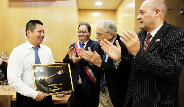 法国国际旅游联合会主席杜吕克(右一)、17区负责商业的副区长盖尔(左二)等向聚宾饭店诸老板(左一)获得金叉奖表示祝贺。