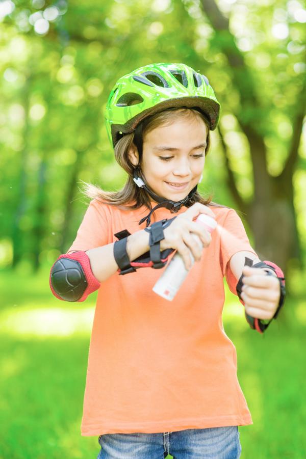 小女孩喷洒防蜱喷剂。(123RF)