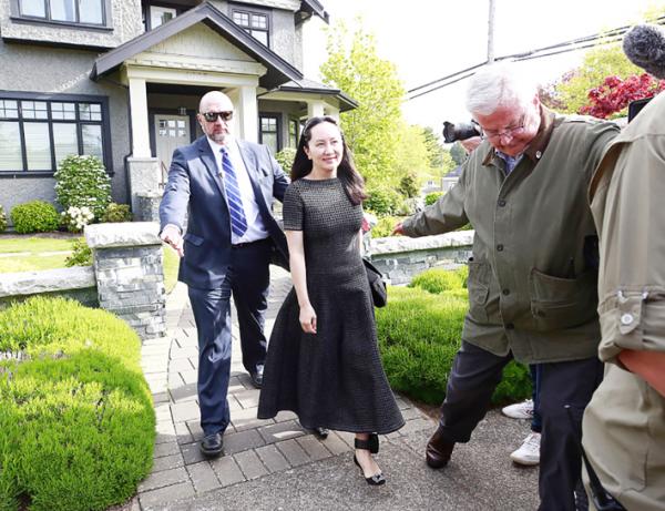 孟晚舟在安保人员陪同下离开住宅,佩戴的黑色电子监控脚环首次被曝光。 (Getty Images)