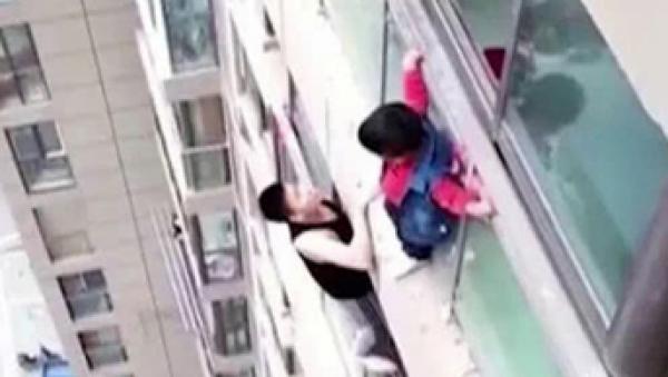 男子救助爬上14楼外墙的一名男孩。(视频截图)