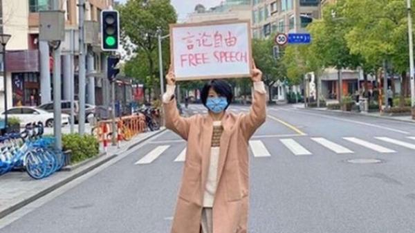 上海市一名戴着口罩的短发女子高举“言论自由 ”的纸牌(网络图片)