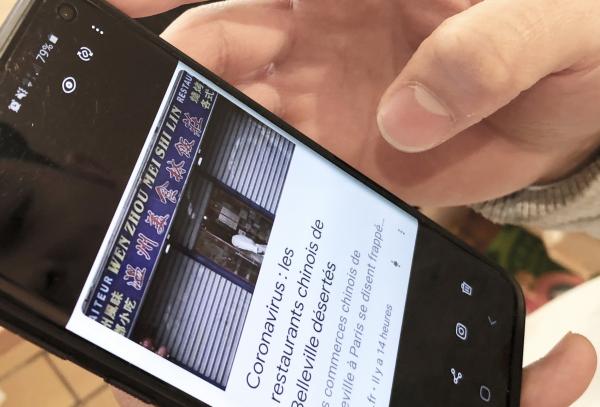 美食林老板Albert在手机上保留了某法媒刊登其餐馆关门配图的照片。(摄影:林莲怡/看中国)