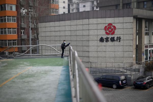 武汉一厅级干部一家被曝感染武汉肺炎后拒绝就医，甚至还在小区散步，完全无视是否传染他人。图为一名戴着口罩的男子于2020年2月13日在北京的一个立交桥上进行体育锻炼。（图片来源：Getty Images)