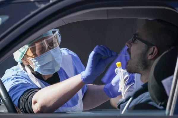2020年4月7,英国沃尔夫汉普顿的中共肺炎病毒测试站,医护人员在用采集棒采集样品。(图片来源:Christopher Furlong/Getty Images)