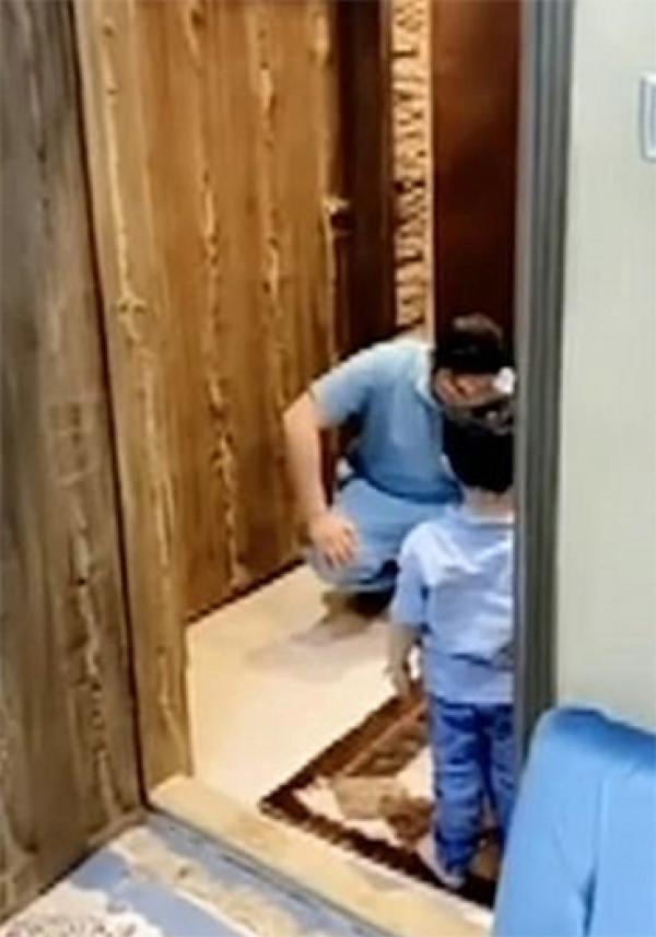 父亲无奈蹲下扶额。(视频截图)