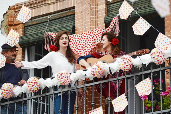 西班牙人在阳台上庆祝传统四月节。疫情放缓,禁足措施将进一步放宽。(AFP via Getty Images)