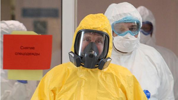 俄罗斯总统普京（前）3月25日在脸书高调秀出自己全副武装，视察收治感染病毒患者的医院。（AFP/Getty Images）