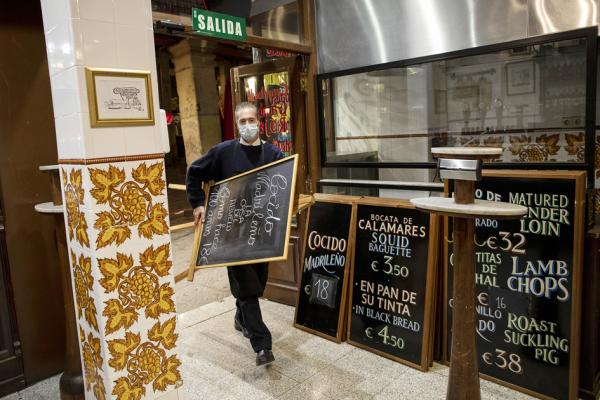 10月25日,马德里一餐厅店员准备关门。西班牙Covid-19感染病例激增,当局宣布国家紧急状态。(Pablo Blazquez Dominguez/Getty Images)