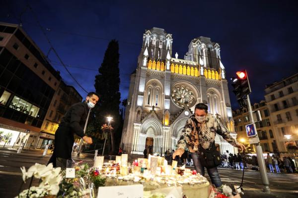 尼斯圣母院遭受恐怖袭击第二天,民众正在圣母院门口摆放蜡烛和花束哀悼死者。(VALERY HACHE/AFP via Getty Images)