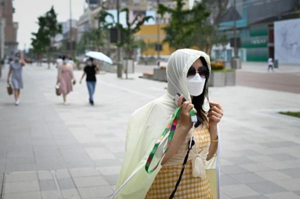 一名戴着口罩的女子在街上行走。(WANG ZHAO/AFP via Getty Images)