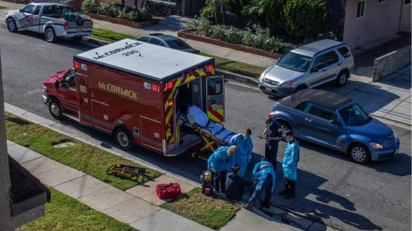 2020年12月29日,加州洛杉矶县一位病人坐在街边等待医护人员送去检测是否感染武汉肺炎。(图片来源: APU GOMES/AFP via Getty Images)