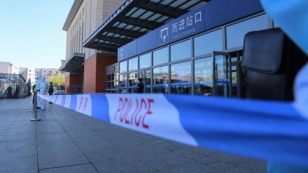身穿防护服的警察在火车站外站岗。(图片来源:STR/AFP via Getty Images)
