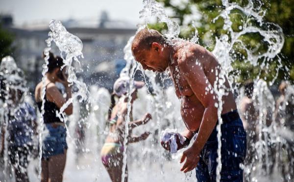 恐怖热浪袭击北美多地 图为6月24日,一名男子在喷水池喷水降温。(图片来源:ALEXANDER NEMENOV/AFP via Getty Images)