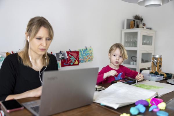2021年2月18日，一女士居家工作，她的女儿在旁边画画。（Christian Ender/Getty Images）