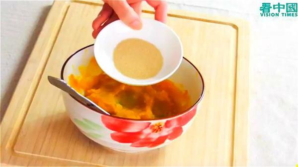  趁南瓜温热的时候，放入酵母粉，均匀搅拌。