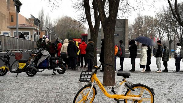 2022 年1月20日,北京下雪天,人们排队接受 Covid-19 冠状病毒检测。(图片来源:NOEL CELIS/AFP via Getty Images)