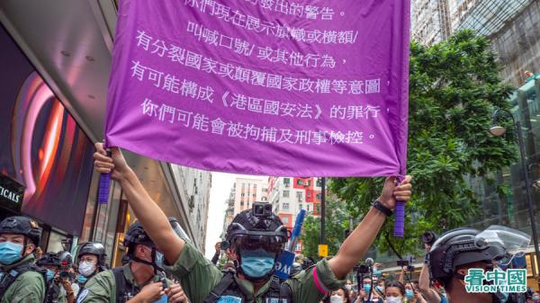 2020年《港区国安法》生效,港警高举举紫旗警告香港市民噤声。(图片来源:庞大卫/看中国)