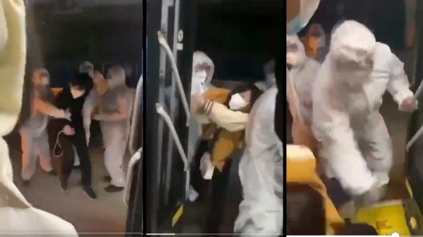 近日一群身穿防护衣的军人粗暴的将民众推上隔离专车,令当地市民愤怒。(图片来源:视频截图)