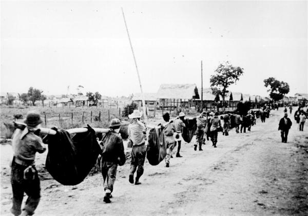 “巴丹死亡行军”(Bataan Death March),是日军于二战太平洋战争犯下最臭名昭著的暴行之一。1942年初,巴丹半岛战役美军战败,约7.6至7.8万名美国和菲利宾战俘被虐待、屠杀,并在疲惫、营养不良、满身伤病的情况下被强迫徒步赶往100公里外的地点。照片中战俘们在行军中肩扛的是病倒的战友,乃至遗体。(Emir214\Wikipedia\公有领域)