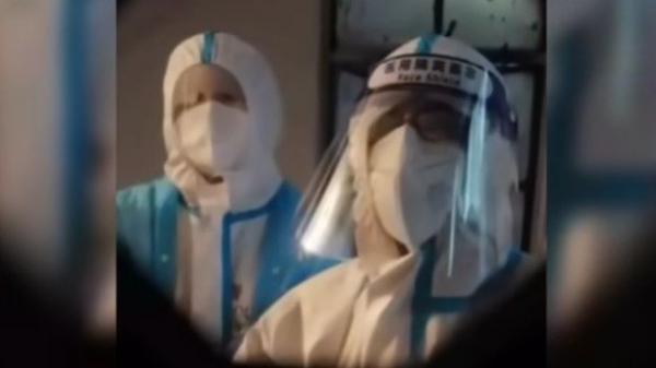 网传上海浦东新区某街道防控办一群工作人员,自称到居民楼通知居民整楼去酒店集中隔离。(图片来源:视频截图)