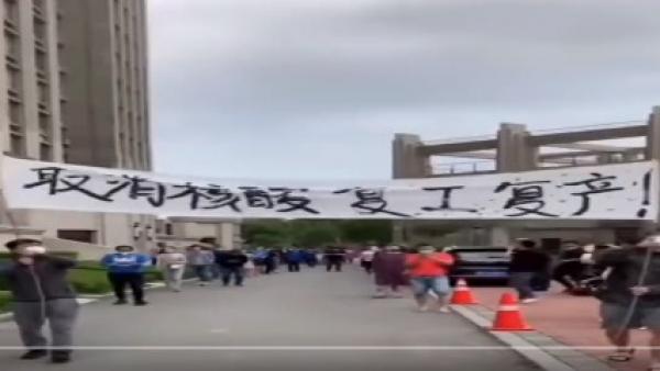 辽宁丹东防疫封控50天,丹东部分市民忍无可忍走上街头举横幅,高呼:“取消核酸 复工复产”。(图片来源:视频截图)