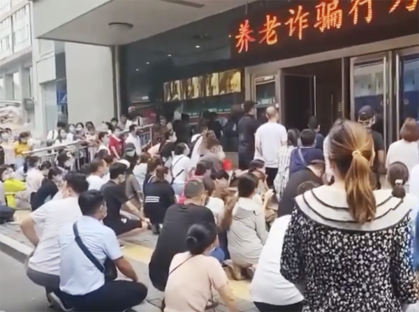 8月9日,上百名业主在房管局门口下跪,要求已停工8个月的洛阳旭辉时代天际楼盘复工。(视频截图)