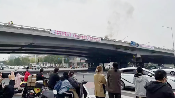 2022年10月13日，北京四通桥一名男子挂横幅抗议，相关画面在网络疯传。（网络截图）