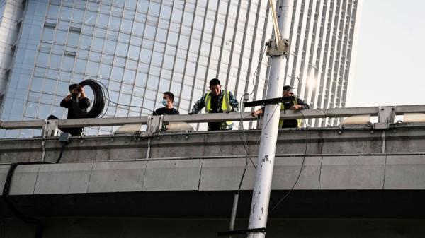 2022年10月13日一名抗议者在北京四通桥悬挂“反党”横幅后画面。(图片来源:NOEL CELIS/AFP via Getty Images)