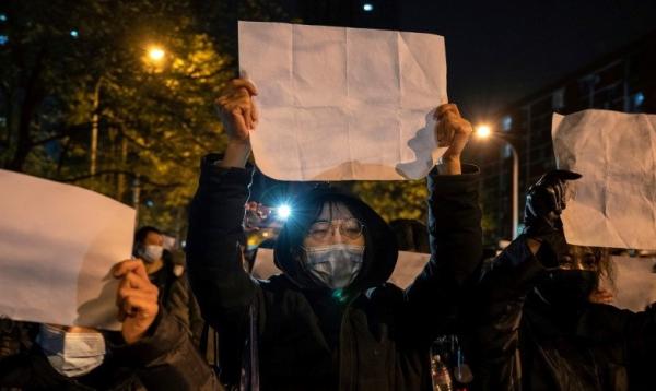 2022年11月27日,市民在北京游行时举着一张反对审查制度的白纸(图片来源:翻拍)