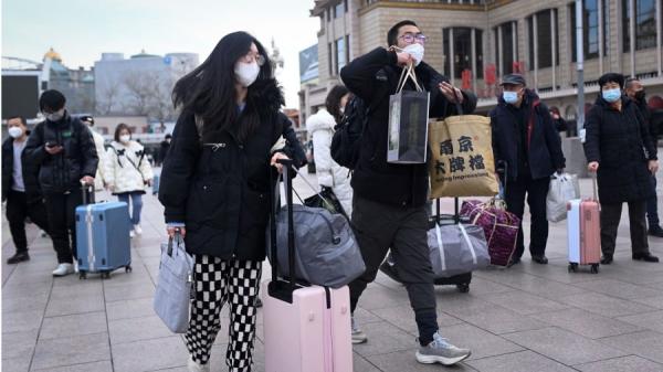 2023年1月7日,乘客背着行李前往首都北京火车站的入口。(图片来源:WANG ZHAO/AFP via Getty Images)